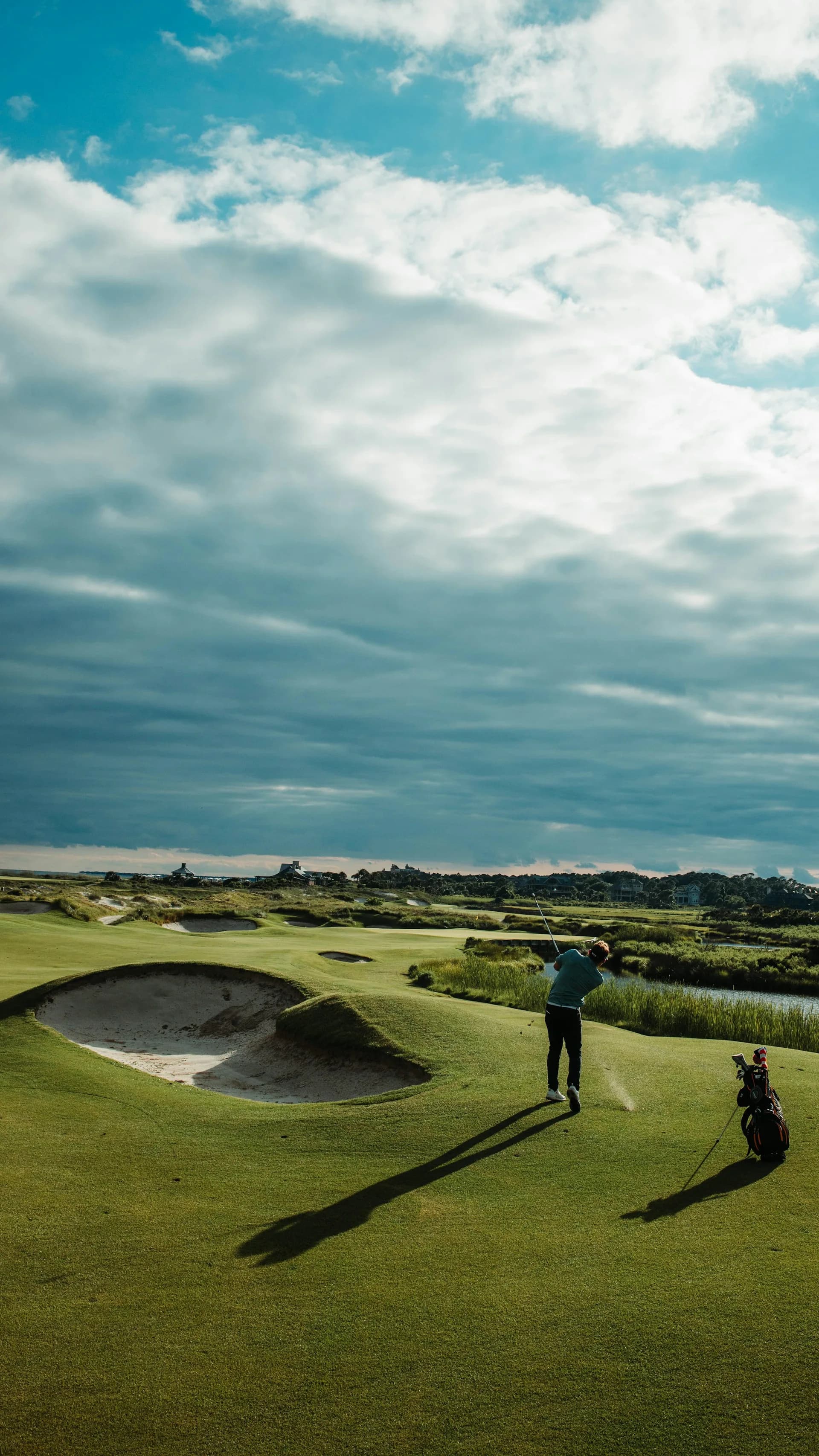 A player mid-swing on a coastal links course